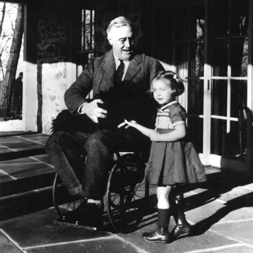 A fényképek is ritkák, amelyen Roosevelt kerekesszékben látható: ezen a fotón az elnök kutyájával és egy alkalmazottjának unokájával látható