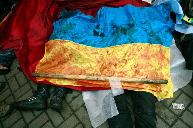 Kormányellenes tüntetők véres ukrán nemzetiszínű zászlóval letakart holtteste a kijevi Függetlenség terén, a Majdanon 2014. február 20-án. Fotó: Beliczay László (MTI/MTVA) 