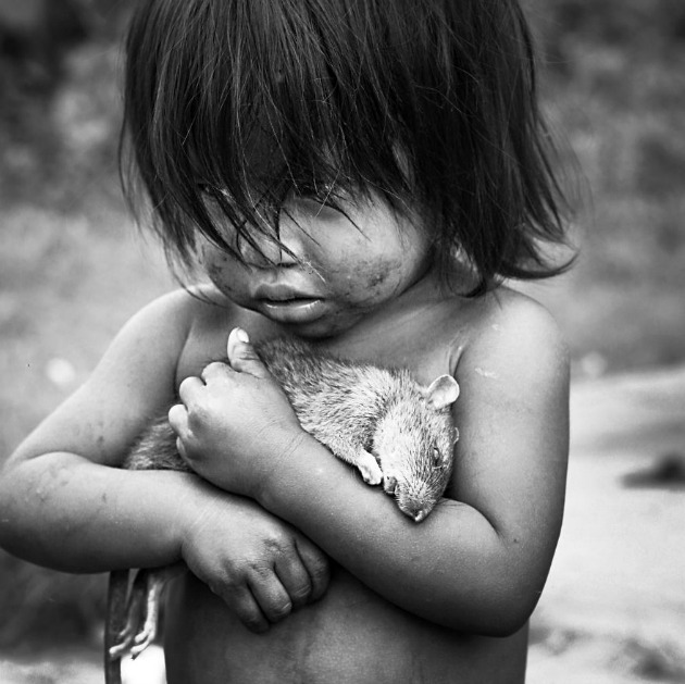 Guaraní kislány szorít magához egy döglött patkányt
